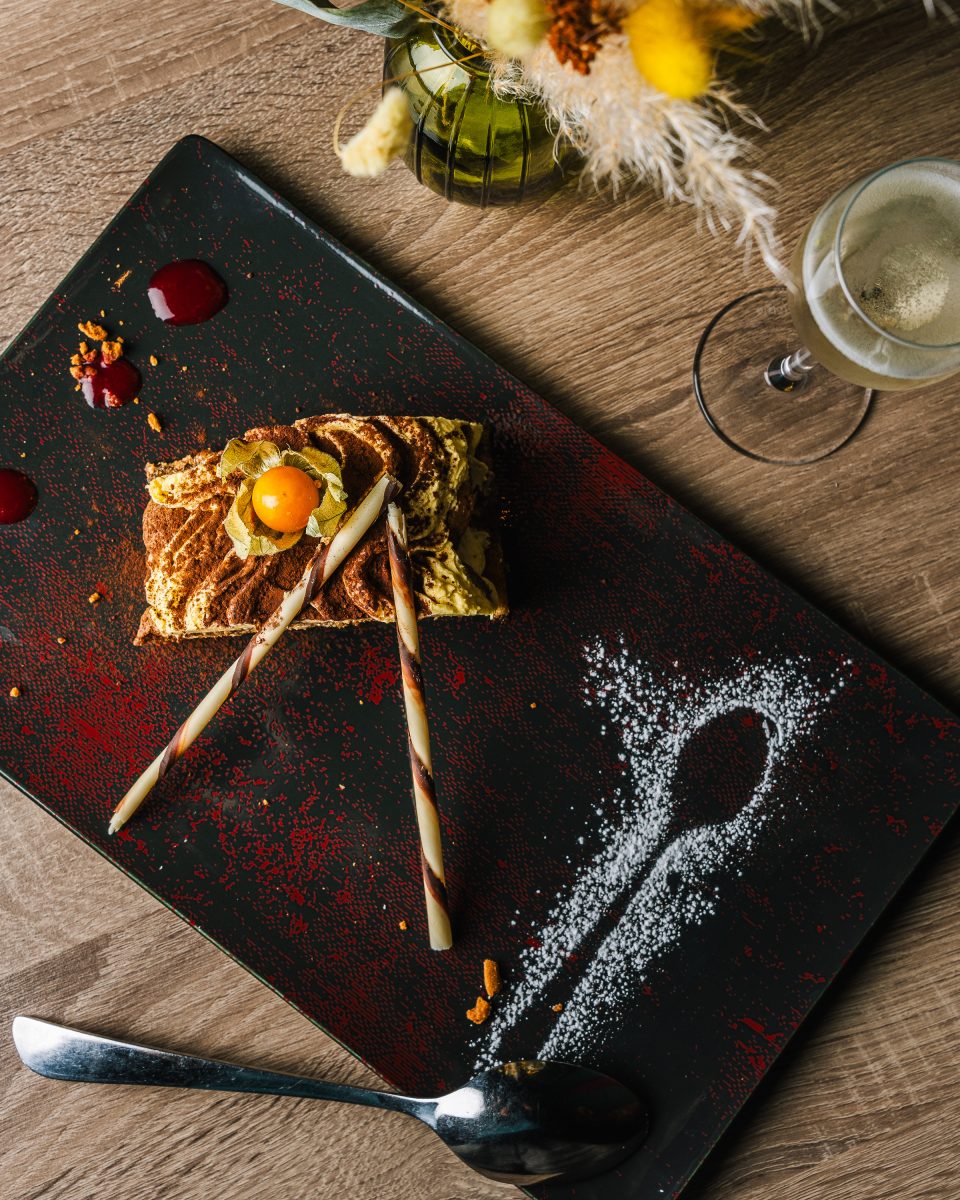 Dessert dressé sur une assiette noire avec verre de vin