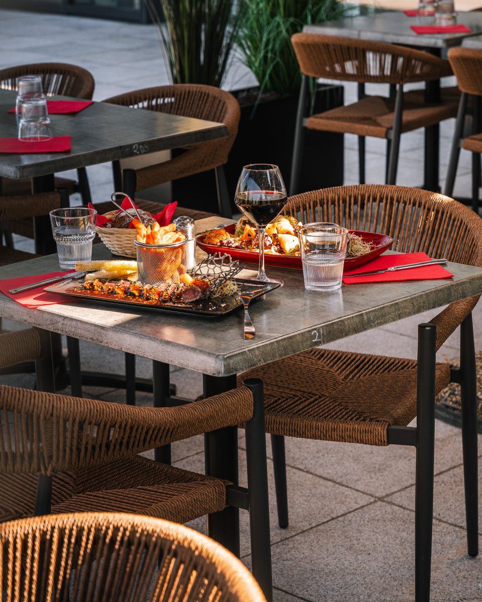 Table dressée en terrasse au Duplex avec assiettes et verres